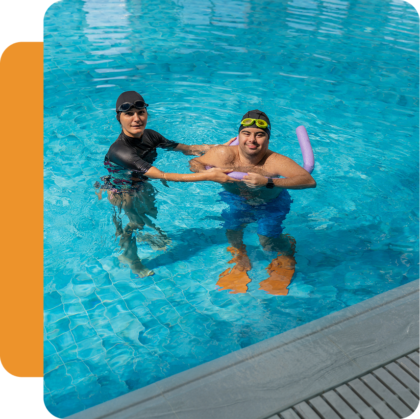 Two people swimming in a pool.