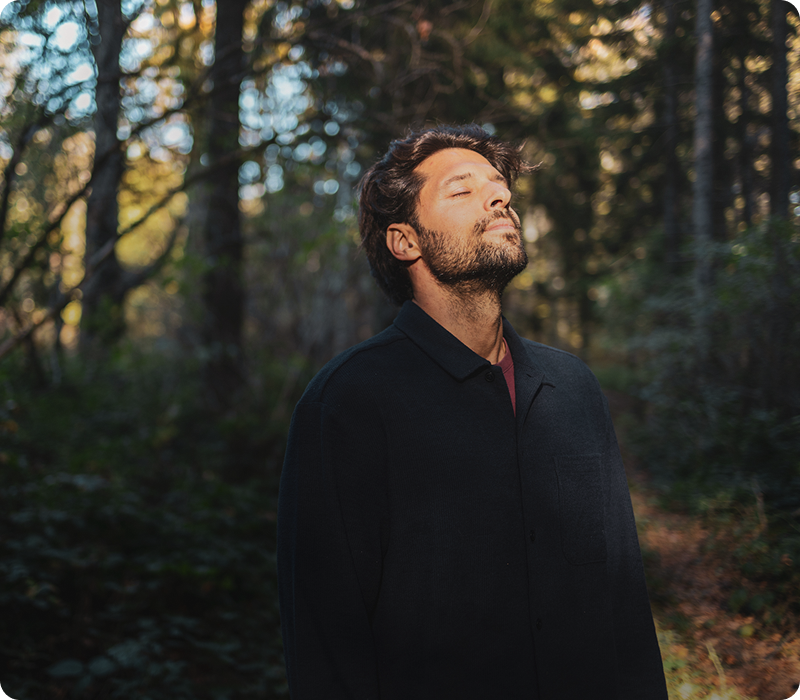 Man enjoying nature in a sunlit forest.